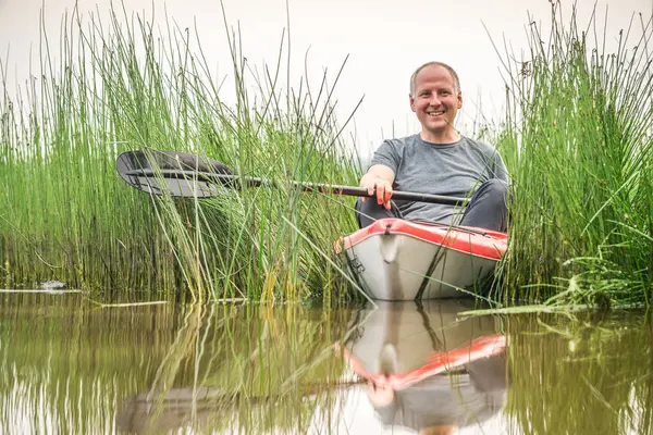 L'uomo in kayak pagaia attraverso l'erba costiera — Foto Stock