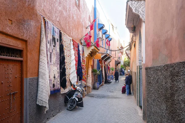 Keskeny utca szőnyegbolttal a régi város Marrakech, Morroco — Stock Fotó