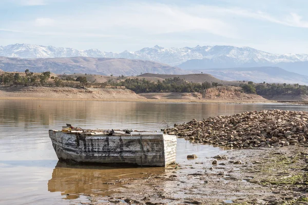 Bateau en bois sur la rive du lac Takerkoust avec montagnes Atlas — Photo