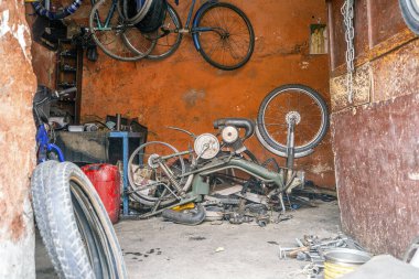 Fas 'taki dağınık turuncu garajda kırık bir motosiklet.