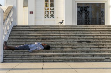 Mozambik 'teki Maputo Katedrali' nin merdivenlerinde dinlenen bir adam.
