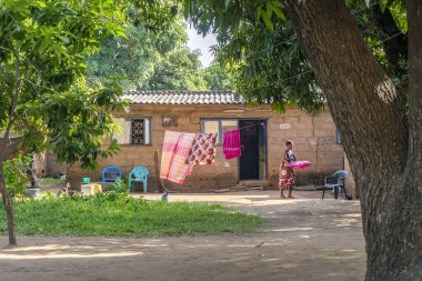 Matola, Mozambik - 23 Mayıs 2019: Afrikalı kadın basit, temiz evinin önünde günlük ev işleri yapıyor 