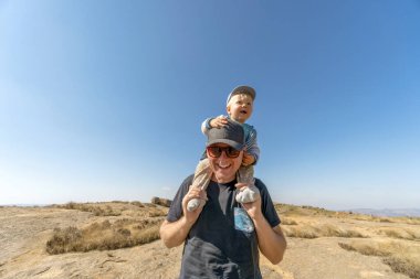 Sevimli, mutlu bir yaşındaki oğlu Eswatini, Afrika 'da babasının omuzlarına biniyor.