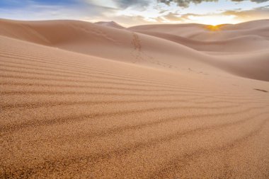 Sahra Çölü 'nün, Fas' ın, Afrika 'nın kum tepeleri üzerinde güzel bir gün batımı.