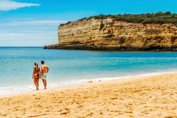ポルトガルのアルガルヴェにある崖のある美しい砂浜を楽しむ若いカップル — ストック写真