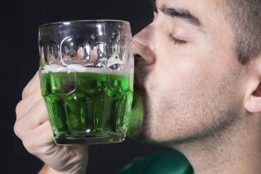 Aziz Patrick gününde yeşil birayı öpen adam