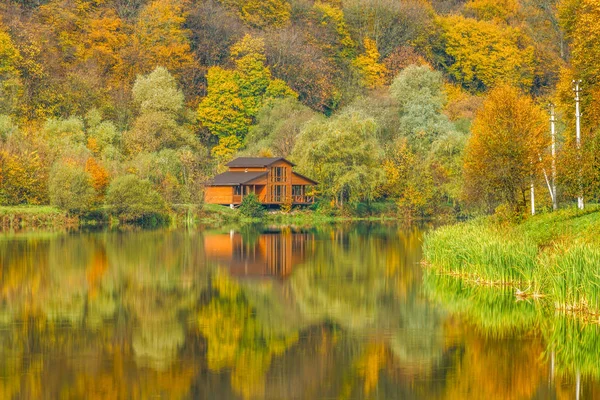 Casa do pescador no lago na floresta de outono . — Fotografia de Stock