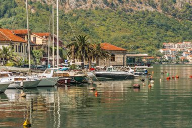 Deniz kıyısı köyünün yakınındaki su üzerinde balıkçı tekneleri ve küçük yatlar. Kotor Körfezi (Adriyatik Denizi), Karadağ.