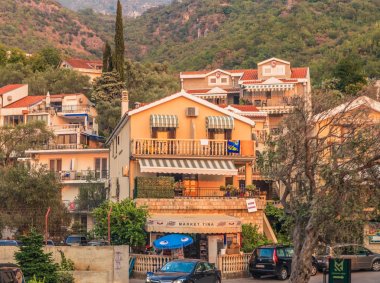 Budva, Karadağ - 26 Ağustos 2017: Binaların kıyısında günbatımı ışınlarının Budva Riviera, parçası. Budva Karadağ başlıca turistik merkezi olduğunu.