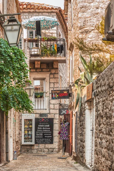 Budva, Montenegro - 28 de agosto de 2017: Old Town Street Budva, Montenegro. La primera mención de esta ciudad - hace más de 25 siglos. Vemos casas antiguas, una calle muy estrecha, cafés, tiendas . — Foto de Stock