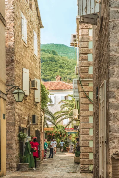 Budva, Montenegro - 28 de agosto de 2017: Ciudad Vieja Budva, Montenegro. La primera mención de esta ciudad - hace más de 26 siglos. Vemos casas antiguas, una calle muy estrecha, cafés, tiendas . — Foto de Stock