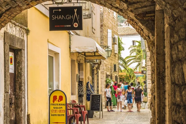 Budva, Montenegro - 28 de agosto de 2017: Ciudad Vieja Budva, Montenegro. La primera mención de esta ciudad - hace más de 26 siglos. Vemos casas antiguas, una calle muy estrecha, cafés, tiendas . — Foto de Stock