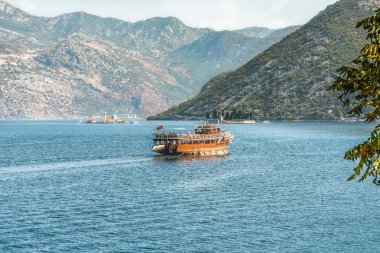 Kotor Körfezi koca Balkan Dağları ve iki güzel Adaları arka planda Adriyatik Denizi üzerinde bir turist tekne. Karadağ.