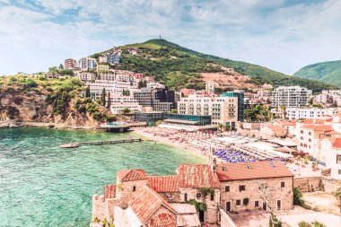  Budva eski kasaba parçası: antik duvarlar ve kırmızı kiremitli çatı ve modern Beach, Karadağ, Europe bir görünüm. Budva Adriyatik Riviera en iyi ve en popüler tatil biridir.
