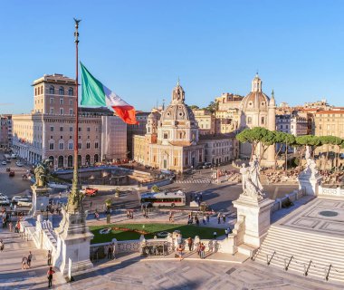 Roma, İtalya - 8 Ekim 2019: İtalya 'da Santa Maria di Loreto Kilisesi ile Venedik Meydanı' nın bir parçası. Ön planda bayrak direğinde İtalyan bayrağı var..