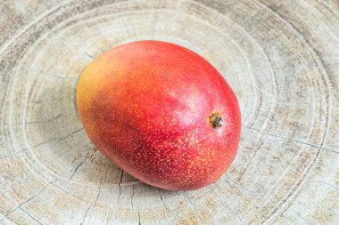 Tahta bir arka planda eşsiz büyüklükte olgun tropikal mango meyvesi..
