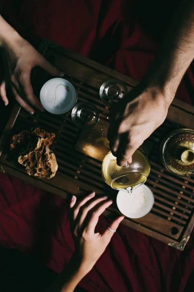 Tea ceremony with tea and friends hands