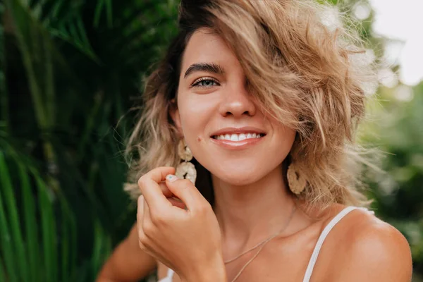 Wanita Eropa yang bahagia dengan gigi putih dan mata hijau mengenakan penghasilan dengan melihat kamera dengan senyum yang indah — Stok Foto