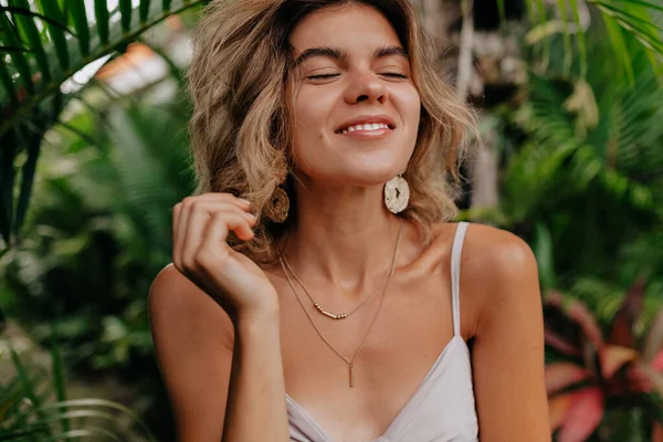 Mulher feliz romântico com cabelos curtos olhos fechados e desfrutar de férias no dia de verão no fundo de plantas exóticas — Fotografia de Stock
