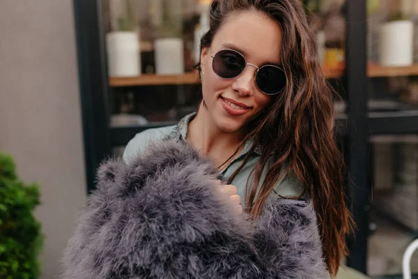 Tutup di luar potret menarik menarik wanita muda mengenakan bulu dan kacamata bergaya berpose di kamera — Stok Foto