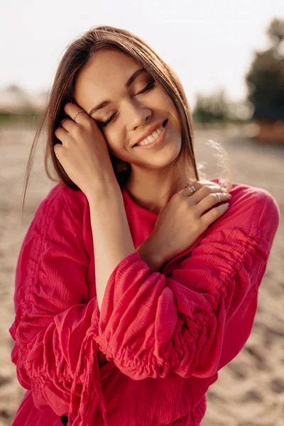 De cerca Retrato de modelo femenino magnífico en blusa rosa ojos cerrados y rostro conmovedor con sonrisa suave — Foto de Stock