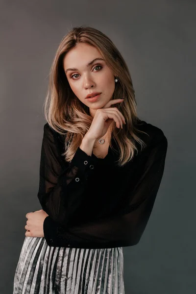 Mulher loira incrível elegante posando na câmera durante a sessão fotográfica sobre fundo cinza. Menina de beleza com cabelo curto e make-up.elegant senhora em vestido preto — Fotografia de Stock