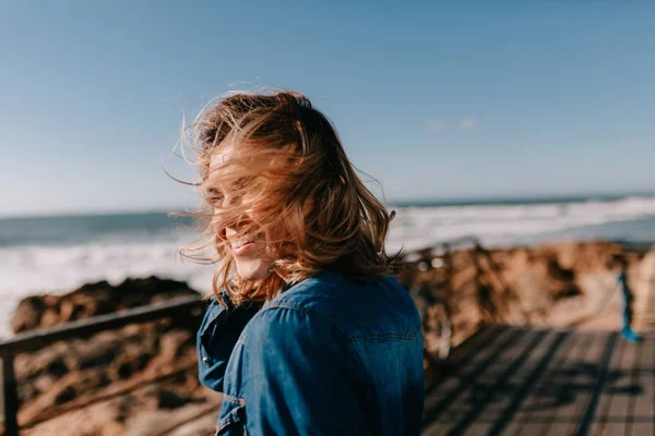 Potret wanita cantik dengan rambut ringan berjalan di pantai laut dan menikmati angin dan matahari . — Stok Foto