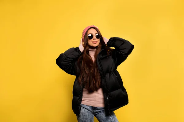 Fashion pretty cool girl in black jacket and sunglasses over colorful yellow background. Confident girl laughing at camera. — 스톡 사진