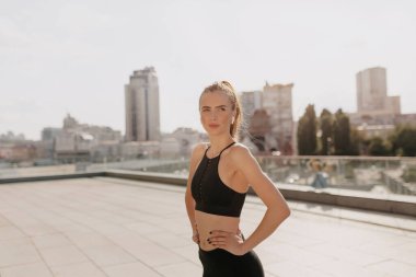 Güneşli bir yaz gününde, dışarıda kulaklıklarla antrenman yapan mutlu ve motive olmuş bir kadın. Dışarıda egzersiz yapan sağlıklı, aktif Avrupalı bir kadın..