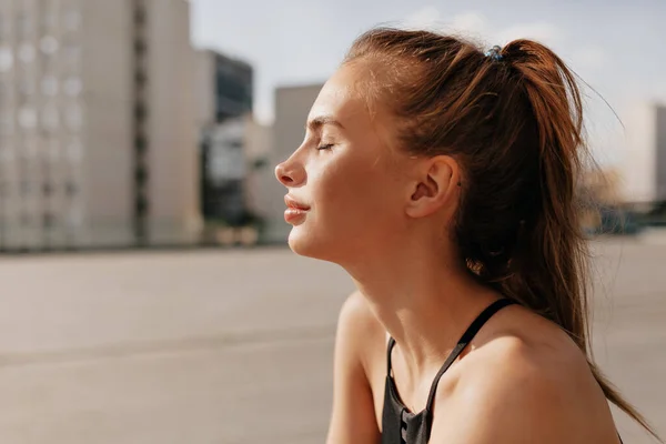 Close up portrait of pretty woman relaxing sunshine in the morning before training. Portrait motivated excited young woman in sportswear smiling, in sunny morning outside — Stock Photo, Image