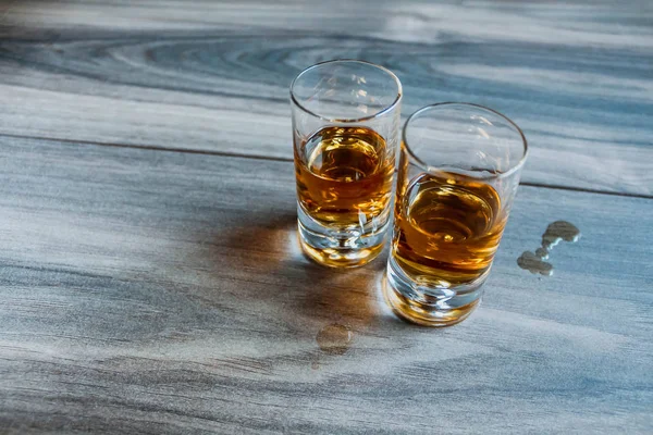 木製の背景にウイスキーと2発のショットグラス — ストック写真
