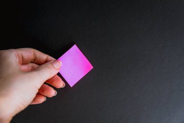 Siyah arkaplan üzerine renkli notları olan bir el 