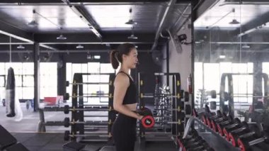 Spor salonunda ağır halterli kadın egzersizi sağlıklı yaşam tarzı kas geliştirici, sporcu kadın dayanıklılık eğitimi güçlü odak pazısı egzersizi. 4k Uhd Görüntü Sinema Yayı
