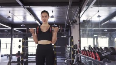 Spor salonunda ağır halterli kadın egzersizi sağlıklı yaşam tarzı kas geliştirici, sporcu kadın dayanıklılık eğitimi güçlü odak pazısı egzersizi. 4k Uhd Görüntü Sinema, Arc çekimi