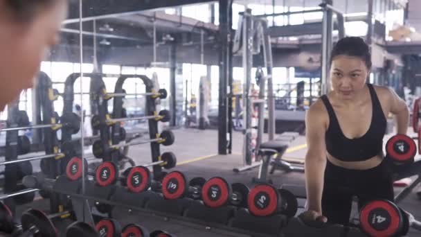 フィットネスジムで重いダンベルと女性の運動健康的なライフスタイルの筋肉ビルダー アスレチックスポーツ女性のトレーニング持久力の強いフォーカスの二足のトレーニング Uhdフッテージ映画 — ストック動画