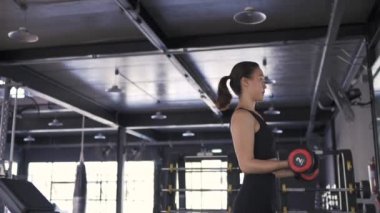 Pan shot, spor salonunda ağır halterli kadın egzersizi sağlıklı yaşam tarzı kas geliştirici, sporcu kadın dayanıklılık eğitimi güçlü odak pazısı. Full Hd Slow Motion Sinematik 