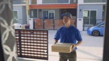 Pizza siparişi veren teslimatçı ön kapıdaki müşteriye gelir, teslimat servisi mutlu bir şekilde güler. 4k Uhd Sineması 'nda çekilmiştir. 