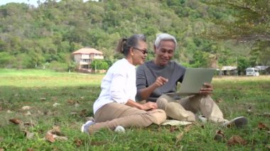 Asyalı yaşlı çift emekli oluyor. Rahatla ve bilgisayar teknolojisini birlikte izliyorlar. Mutluluk, yaşam tarzı, yavaş çekim.