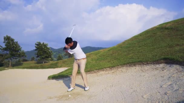 在高尔夫球场上与俱乐部一起散步的职业男子高尔夫球手在球道附近的沙坑中挥杆击球 在暑假期间放松运动 电影Uhd 4K镜头 — 图库视频影像