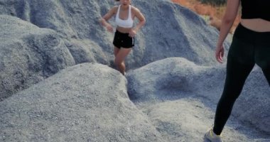 Yavaş Hareket, Patika Koşu eşleri kaya dağına tırmanmaya yardım ediyor. Sporcu iki kadın sporcuya uygun. Açık havada profesyonel spor yapıyorlar. Güzel doğada zor ve zorlu bir yaşam tarzı.