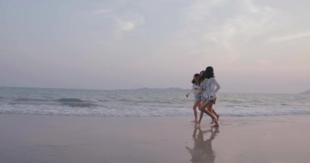笑顔幸せなアジアの友人の女性が一緒にビーチで一緒に海水浴夏休みの夕日シルエット夕暮れ休日旅行生活を楽しむ週末のアクティビティライフスタイル スローモーション4Kシネマカメラ — ストック動画