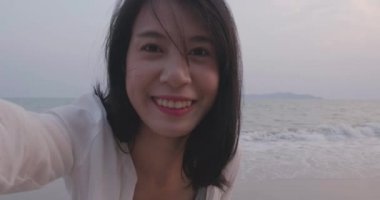 Arkadaş grubuyla selfie kamera geri sayım zamanlayıcısı. Genç kadınlar ekran görüntüsü atlıyorlar. Yaz tatilinde tripoda oturuyorlar.  