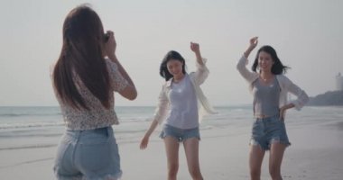 Gülümseyen mutlu bir grup genç kadın arkadaşlarıyla fotoğraf makinesi çekiyor. Yaz tatilinde dans ediyorlar. Günbatımı insanları yaşam tarzları.