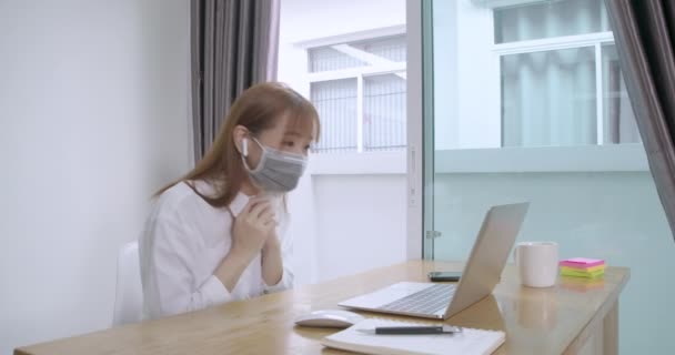ラップトップコンピュータでビデオシリーズを見て幸せな若いアジアの女性は ノートパソコンのコンピュータの隔離と娯楽面白い職場の机を楽しんで自宅に滞在感染の概念を防ぐ — ストック動画