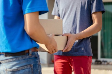 Maskeli teslimatçı, kargo kartonunu ön alıcıya gönder. Virüs tıbbi konsept yayarken kargo sosyal mesafesi dağıt..
