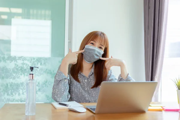 Asian woman pointing correct wearing mask working from home online education , Prevent the spread of coronavirus quarantine for covid-19, Self isolation from society to reduce risks.