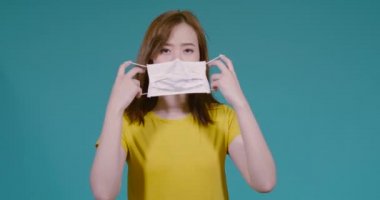 Maskeli genç Asyalı kadın filtreyi korur ve mavi arka planda enfeksiyonu önler, Coronavirus covid19, toz pm2.5 sağlıklı kavram