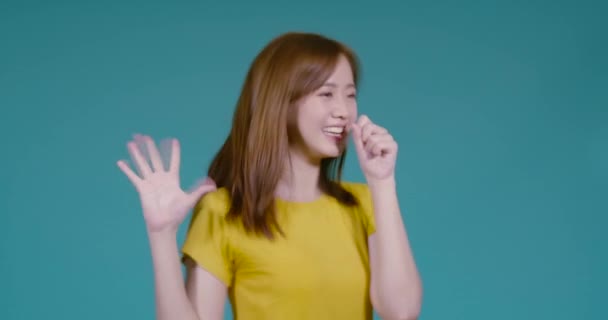 年轻的亚洲女人迷人的歌唱情调热身听起来很开心在蓝色的背景音乐工作室里放松享受生活 — 图库视频影像