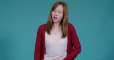 Genç Asyalı kadın mide ağrısı ya da tişört ve ambalaj kağıdındaki karın ağrısı. Mavi arka plandaki sağlıklı hastalık konsepti..