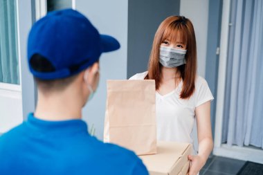 Maske takan Asyalı kadınların sosyal mesafeleri seçmesi, enfeksiyonu önlemesi müşteri alıcısının karantinaya alınırken internetten alışveriş yapması riski..